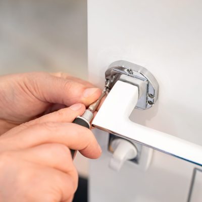 A,Locksmith,Adjusts,The,Door,Handle,Of,A,Modern,White